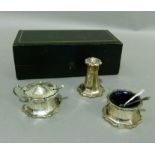 A three piece cruet set of waisted octagonal form with shaped rims and bases, comprising lidded