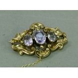 A Victorian amethyst set brooch in 9ct gold the three oval faceted graduated stones collet set