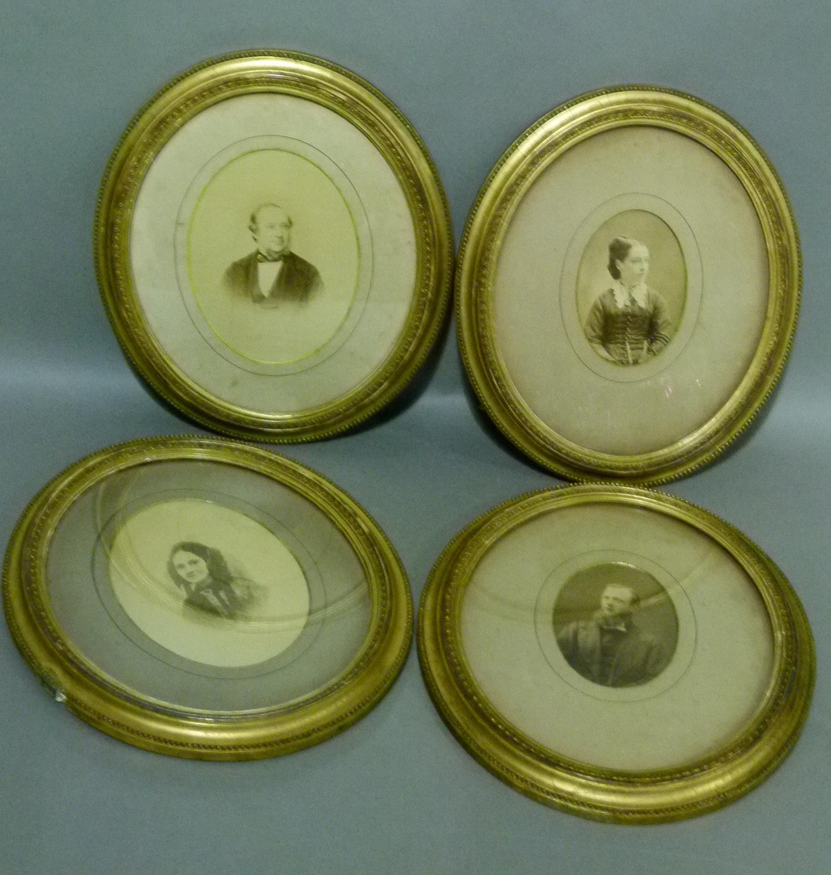 A set of four Edwardian gilt framed photographs, head and shoulder portraits within guilloche and