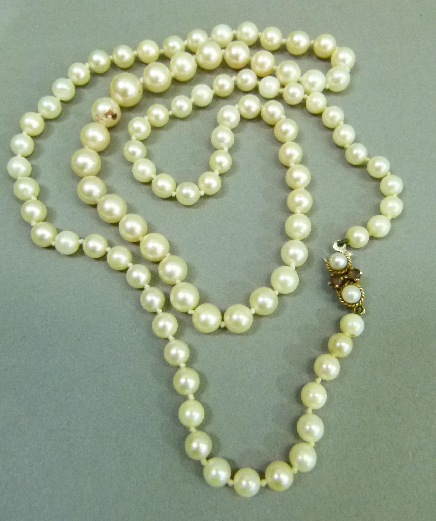 A cultured pearl necklace, the graduated pearls fastened with a 9ct gold pearl and amethyst set