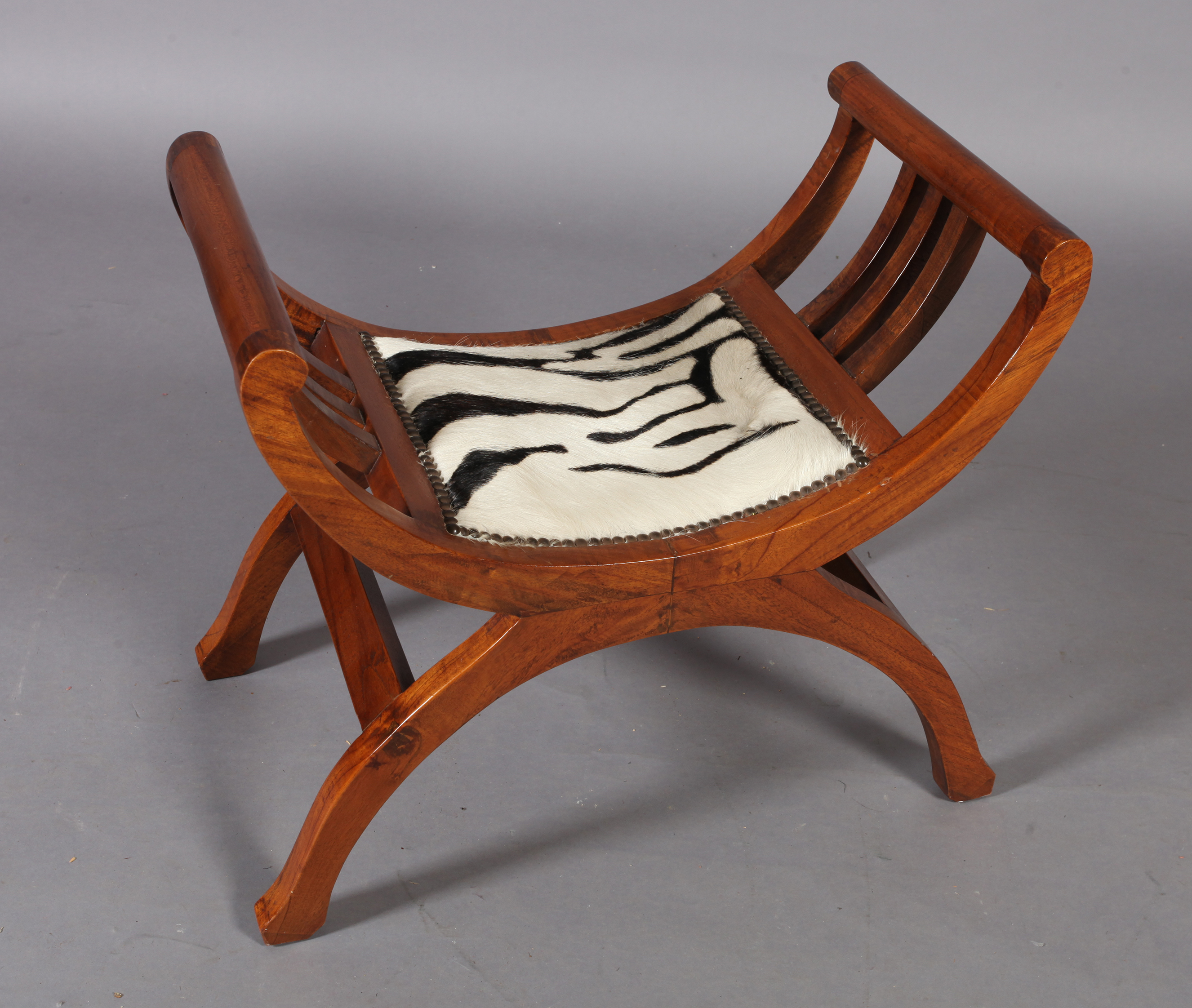 A reproduction hardwood x-frame stool, the seat upholstered with zebra skin within close brass - Image 2 of 4