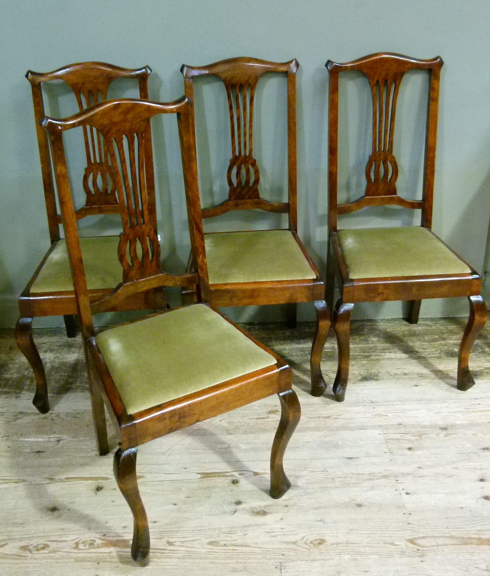 A set of four 18th century style dining chairs with pierced splat upholstered drop in seat and on