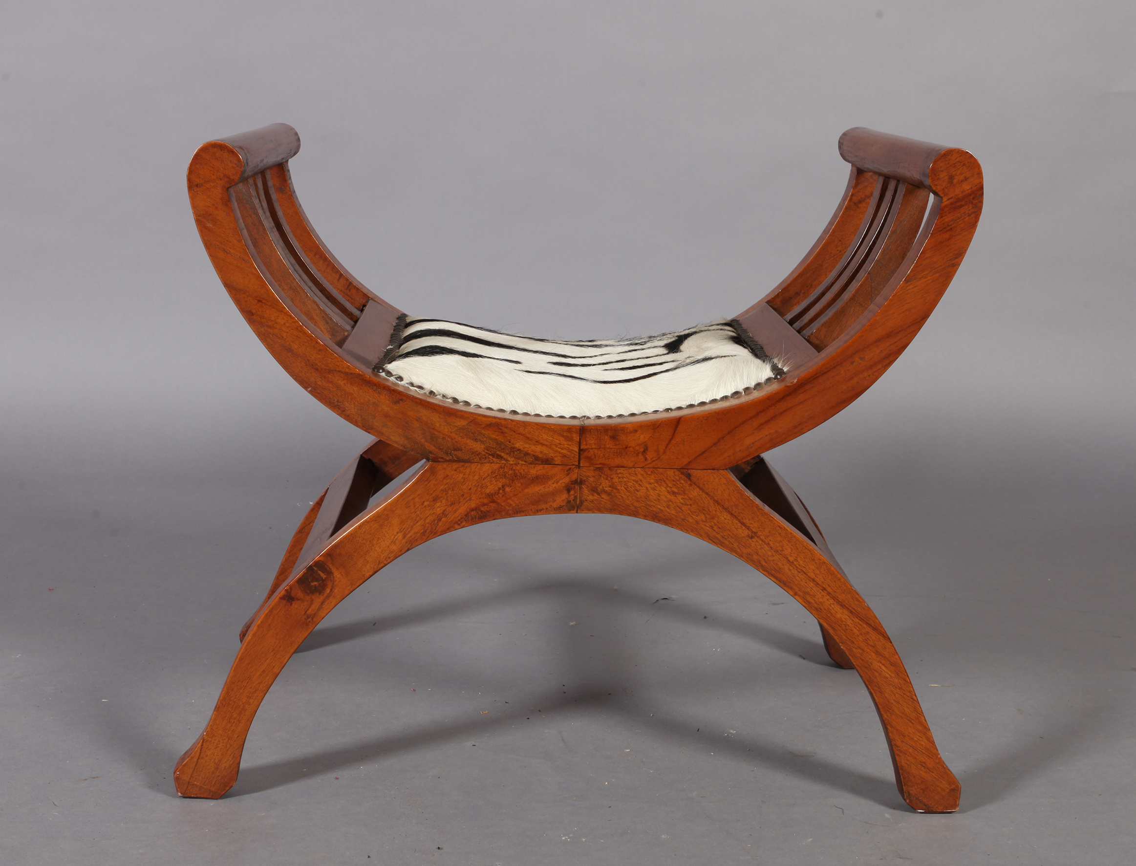 A reproduction hardwood x-frame stool, the seat upholstered with zebra skin within close brass - Image 4 of 4