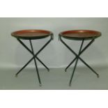 A pair of folding tables with circular dished red lacquer tops with a band of fruit and leafage on