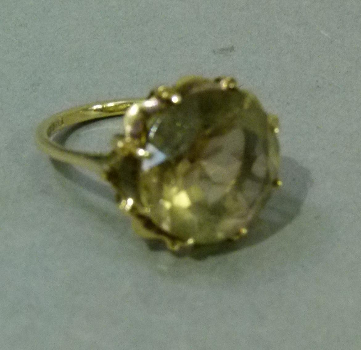 A smoky quartz dress ring in 9ct gold, the circular faceted stone claw set, raised against a star - Image 2 of 5