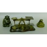 A set of postal scales together with a small quantity of brass weights and a cast metal monkey