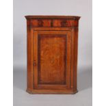 A George III oak hanging corner cupboard with dentil moulded cornice, the single panelled door