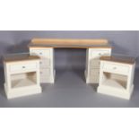 A walnut and cream bedroom suite comprising dressing table with concave centre and pair of bedside