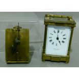 A brass cased carriage timepiece with swing handle, the white enamelled dial with Roman numerals