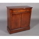 A reproduction mahogany cupboard crossbanded and box wood strung, the single frieze drawer baize