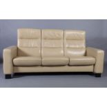 A three seater Stressless sofa upholstered in cream leather, with reclining back, 198cm wide