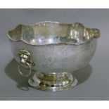 A plated on copper punch bowl having a wavy gadroon rim, lion mask and ring handles, raised on a