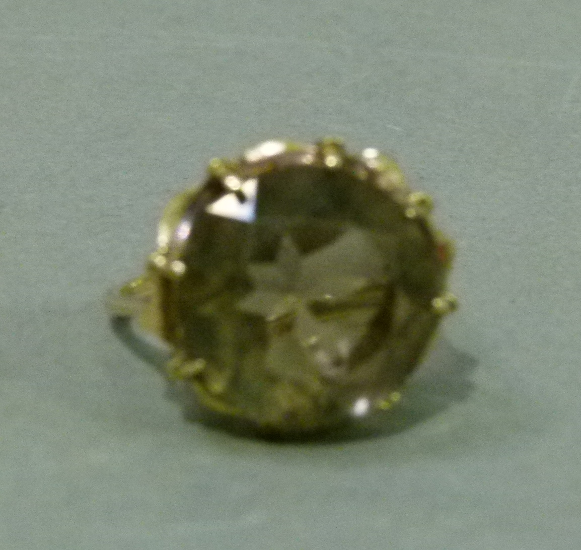 A smoky quartz dress ring in 9ct gold, the circular faceted stone claw set, raised against a star - Image 5 of 5