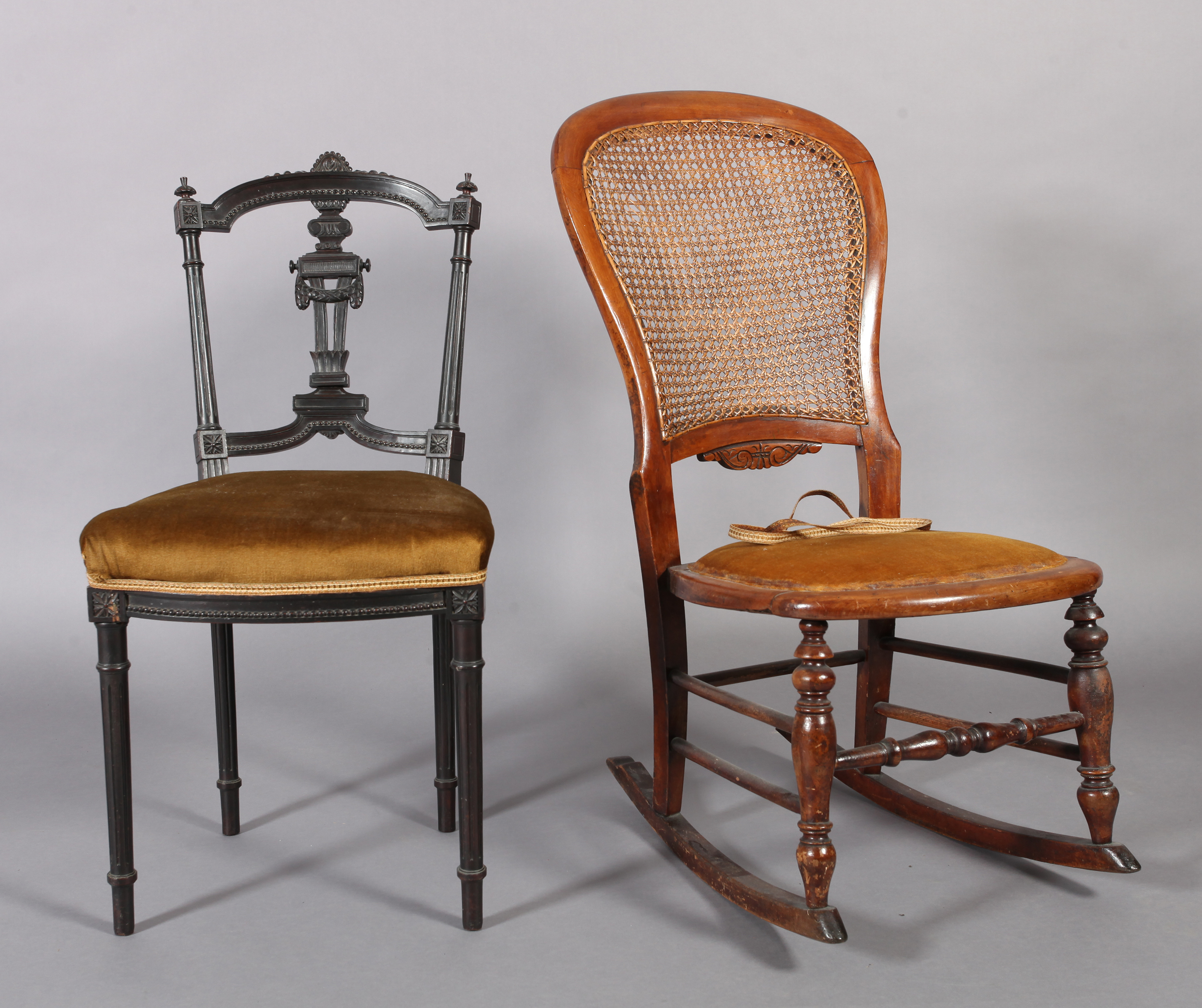 A Victorian walnut framed rocking chair, the back with caned panel above a velvet seat, turned