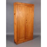 A pine wardrobe of two panelled doors, on skirted plinth 110cm wide x 206cm high