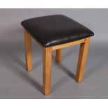 A square footstool with brown simulated leather stuffed over top, 40cm square
