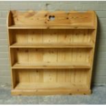 A pine book shelf with shaped top centred on a pierced heart shaped motif, four shelves, 102cm