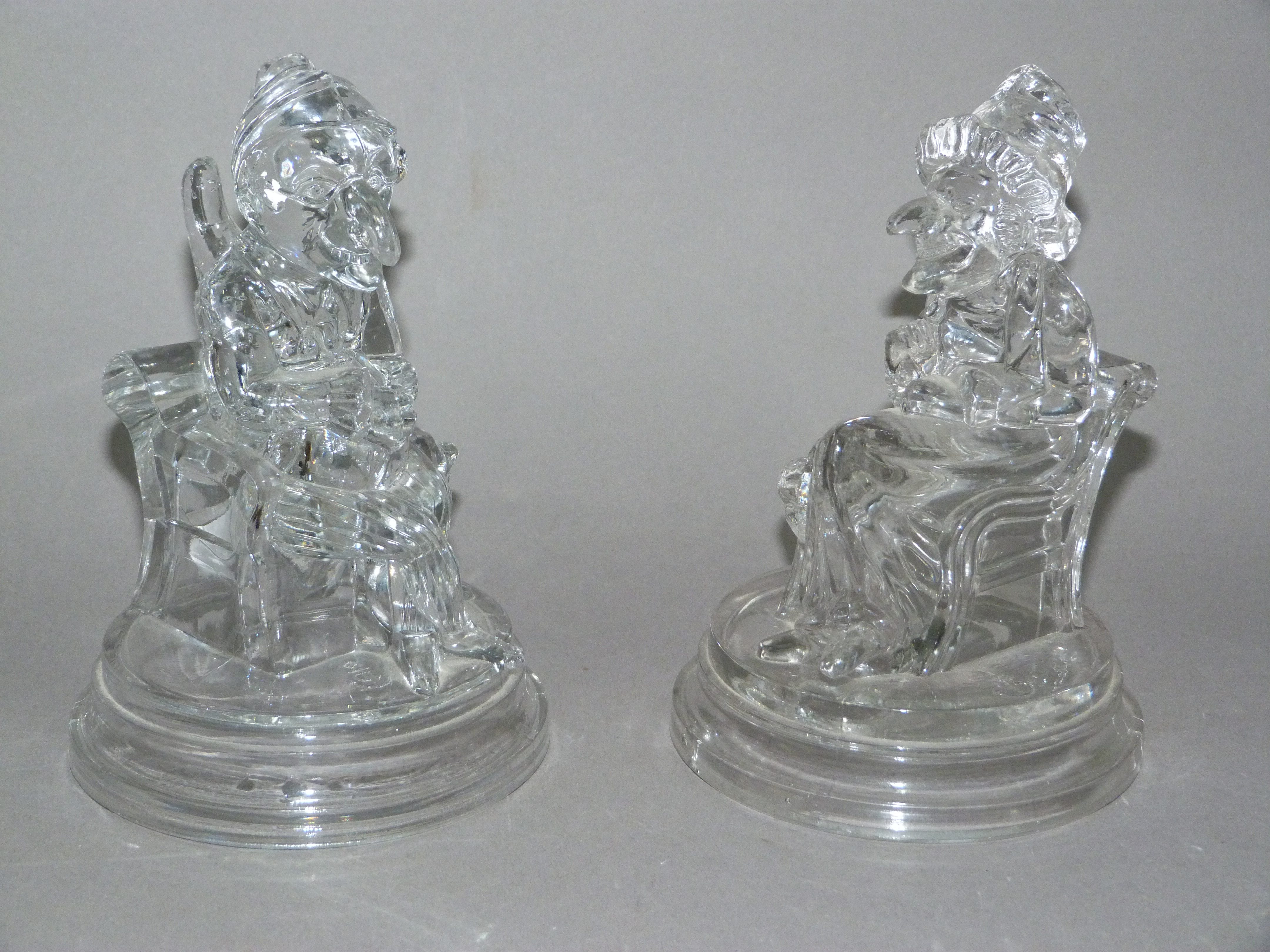 A pair of moulded glass figures of Punch and Judy, the bases moulded with J P and anchor mark, 17.