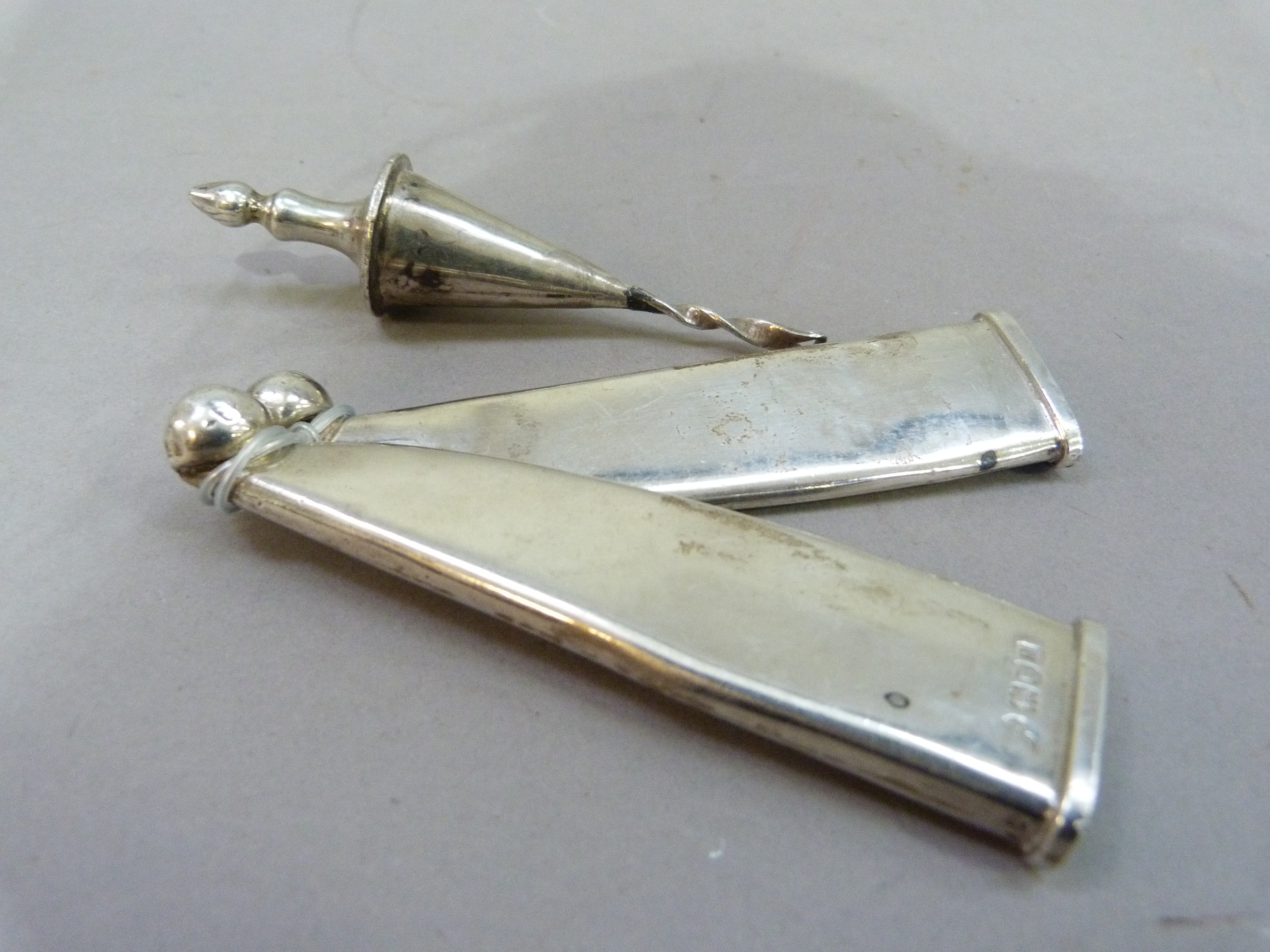 Two silver scabbard tips, 10cm long, indistinct maker's mark, London 1908; together with an urn