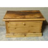 A pine cupboard, rectangular top above a drop down front on skirted plinth, 84cm wide x 45cm high