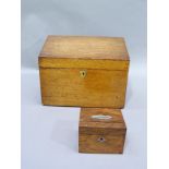 An oak box fitted for stationery to the interior together with a small money box