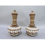 A pair of Doulton silicon ware bottle vases and covers with buff bodies, relief decorated with bands