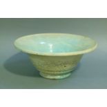 A circular bowl, the raku glaze tinted from duck egg blue to turquoise, on circular foot, 32cm