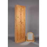 A pine wardrobe enclosed by a pair of fielded panel doors, 204cm high x 56cm wide x 28cm deep