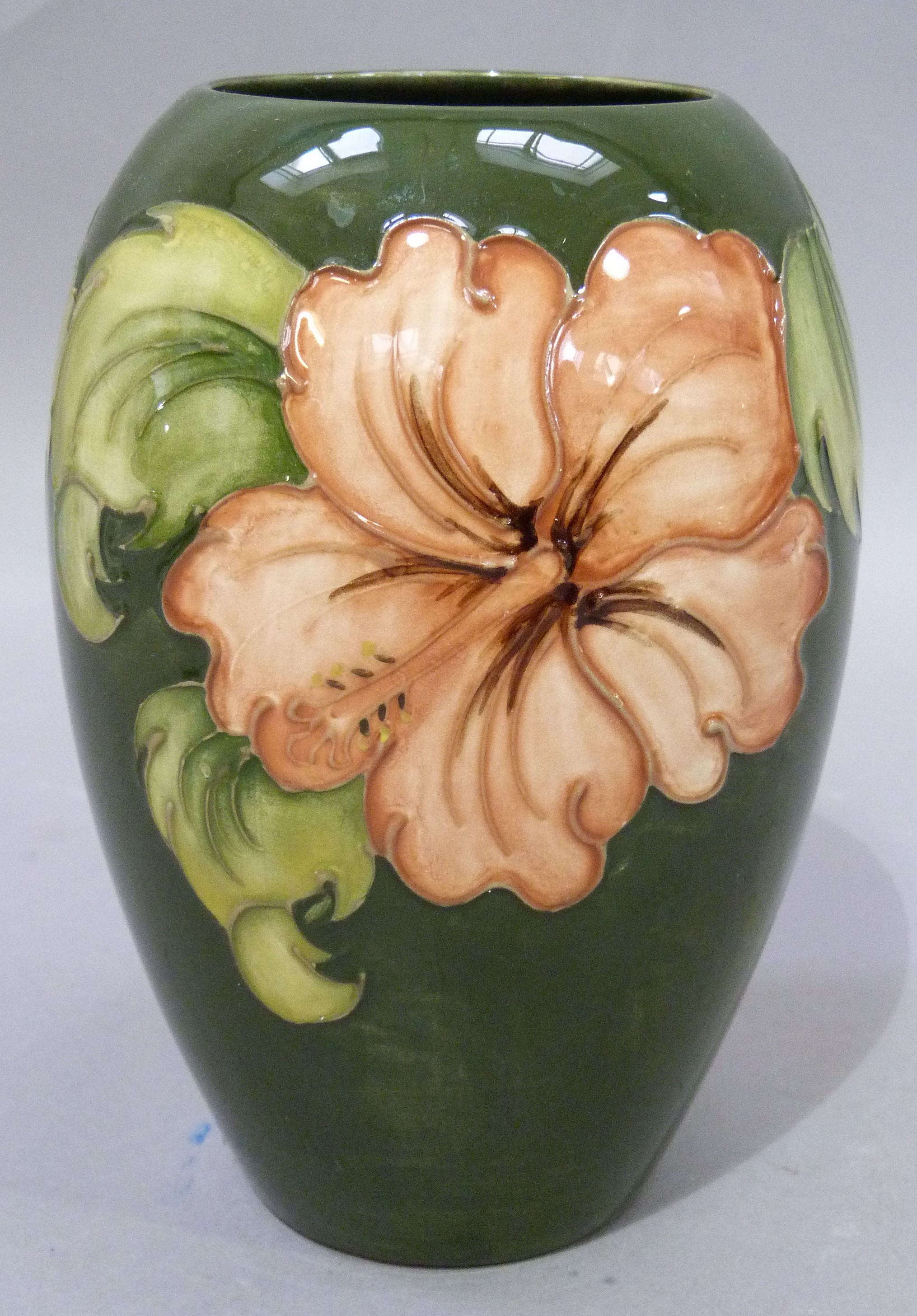 A Moorcroft pottery vase of ovoid shape, tube lined and glazed in coral and green wiith hibiscus,