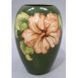 A Moorcroft pottery vase of ovoid shape, tube lined and glazed in coral and green wiith hibiscus,