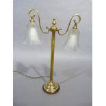 A brass, two light table lamp having two scrolled arms with opaque shades, central column on a