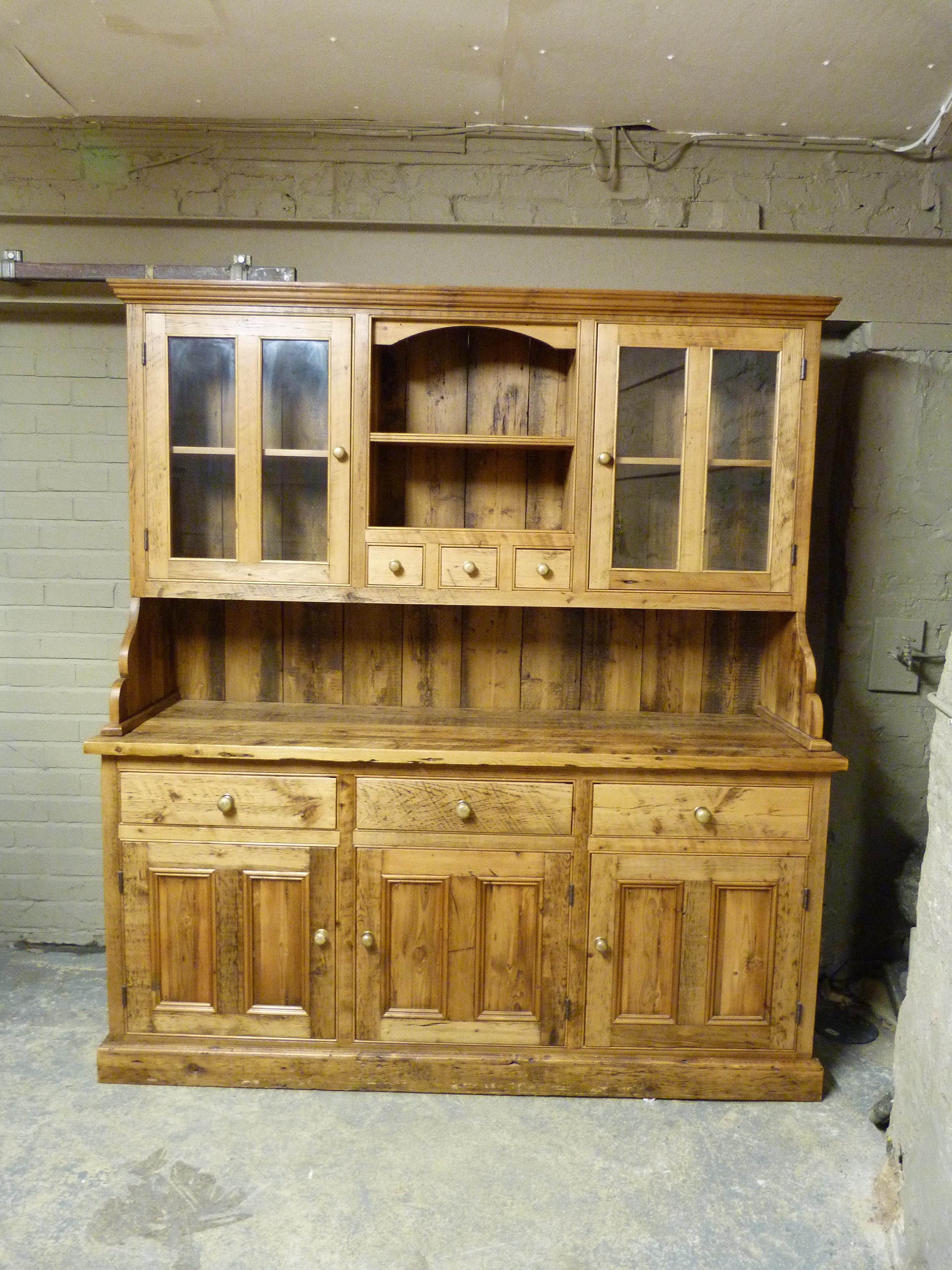 A reproduction pine dresser with flared cornice, the back with central shelf, three small drawers