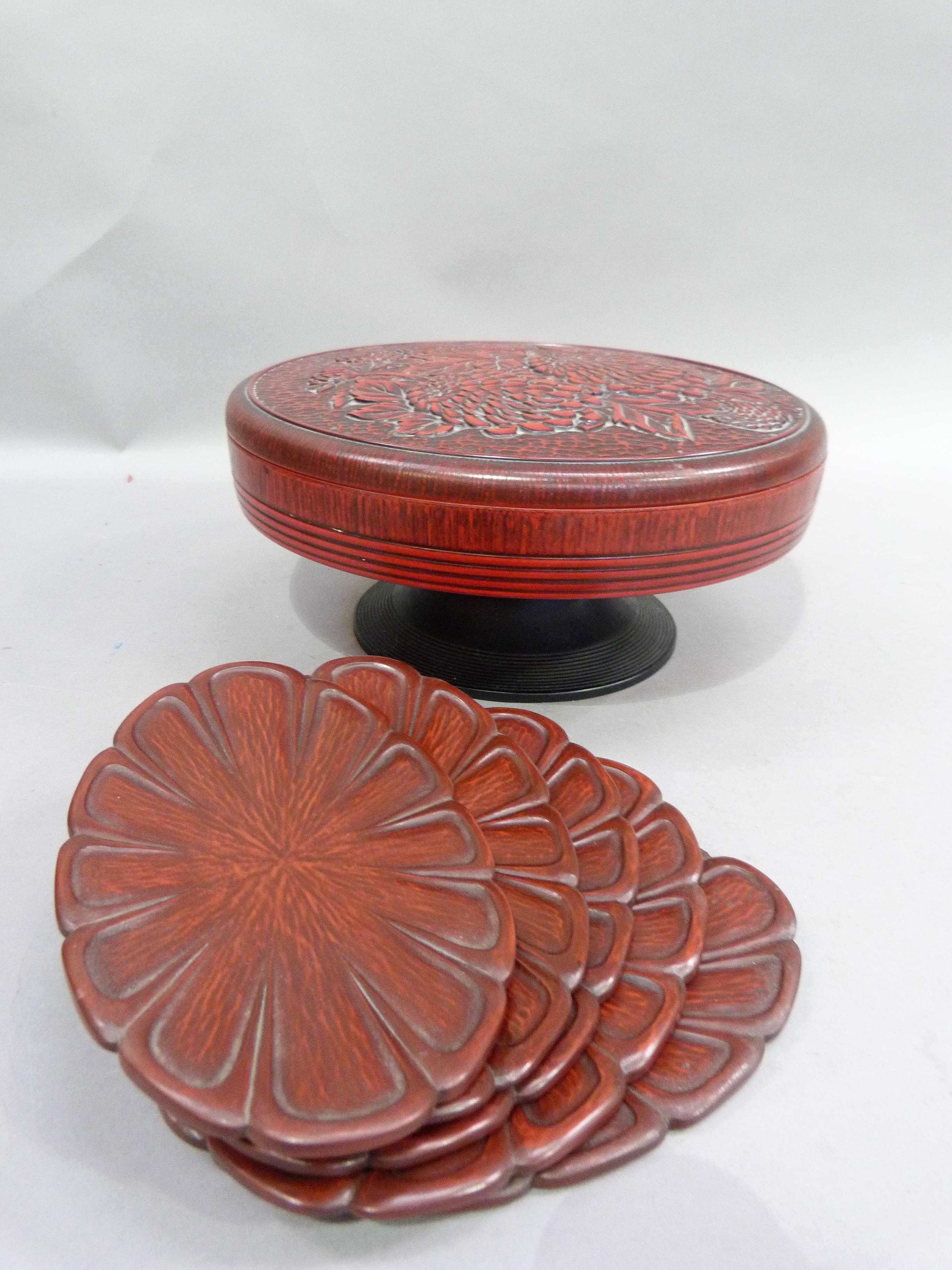 A red lacquered hors d'oeuvre set in a pedestal stand with the cover moulded with chrysanthemum;