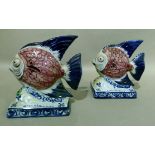 A pair of Portuguese Alcobaca pottery fish ornaments decorated with black scaled pink bodies, blue