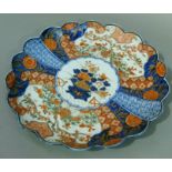 A Japanese Imari petal shaped dish decorated in typical palette, the centre with vase of flowers