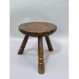 An elm stool, circular dished dished seat on three turned legs, 28cm D x 29cm H