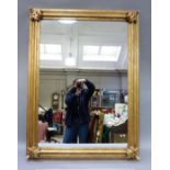 A modern gilt framed wall mirror, the moulded frame with applied leaf corners, rectangular, 123x92