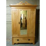 A late Victorian satin-walnut wardrobe with broken cornice centred on a shell above flared dentil