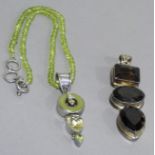 A pendant with facetted quartz pendant and green quartz circlet all collet set in white metal (tests