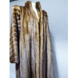 A mink coat by Busvines of London & Paris, having a stand up collar and slit pockets, approx size