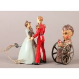 A Vintage Wells Brimtoy clockwork Prince Charming and Cinderella group, blue and red painted