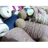 A quantity of knitting wool and yarns in neutral, blues and shocking pink