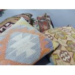 Four various kilim and Caucasian carpet cushions in fox red and blue, black and pink, orange and