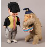A West German clockwork tin plate drumming monkey, blue felt hat, glass eyes and plush body with