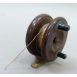 A vintage mahogany fly fishing reel with ebonised handles, brass fitting and fret, 3" diameter