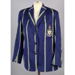 A vintage school blazer in blue with green and white stripe, with badge for Victoria University of