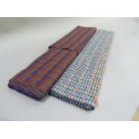 A length of Harris tweed in red and navy check and another length in green, blue and red check on