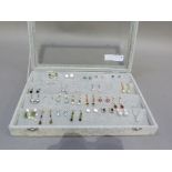 A jewellery box with glazed lid containing approximately 23 pairs of pendant and stud earrings and