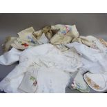 A quantity of table linens including embroidered table cloths, napkins, tea cosy covers, runner