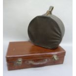 A brown leather covered suitcase; together with an oilskin hatbox containing two lady's hats circa
